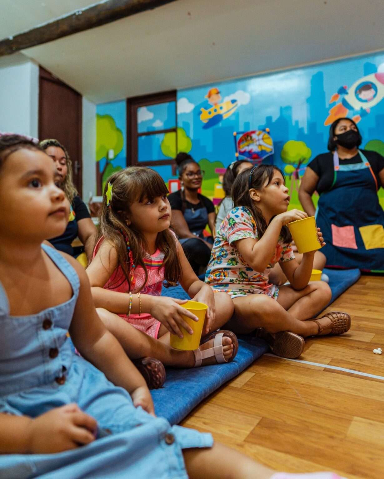 Crianças participando de uma atividade em grupo com monitoras